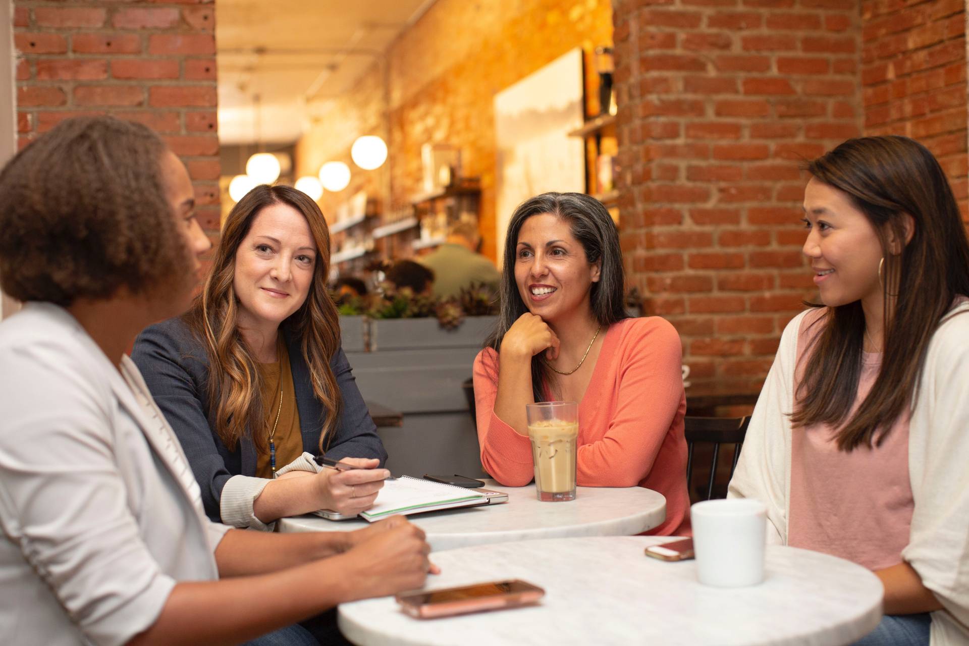 women around table talking conversation starters in sales